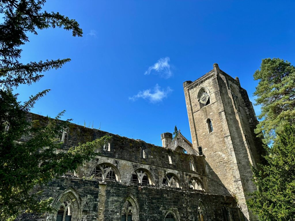 Ancienne tour en pierre sur fond de ciel bleu et feuillage verdoyant